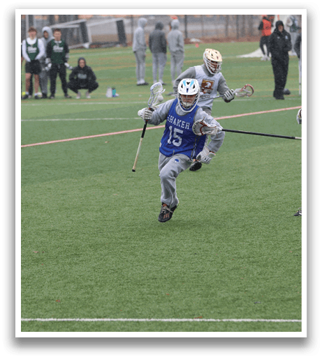 Two men are playing a game of lacrosse on a field. One man is running with a lacrosse stick, while the other man is running behind him. There are several other people on the field, some of whom are holding water bottles. AI generated content