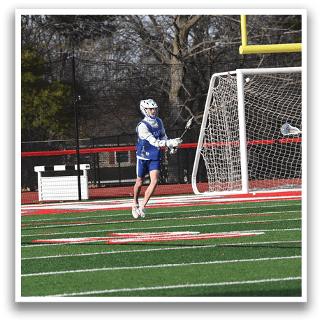 A man in a blue uniform is standing on a field with a soccer goal in the background. AI generated content