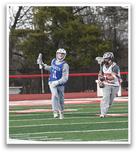 Three people are playing a game of lacrosse on a field. One person is holding a stick and appears to be getting ready to shoot the ball. The other two players are standing nearby, likely preparing for the next play. AI generated content