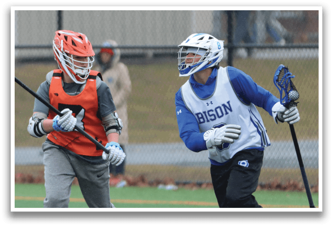 Two men playing lacrosse on a field. One man is holding a stick and the other is wearing a helmet. AI generated content