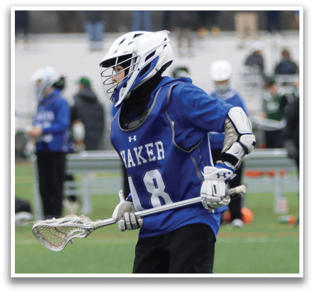 A young man wearing a blue and white uniform is holding a lacrosse stick and walking on a field. AI generated content