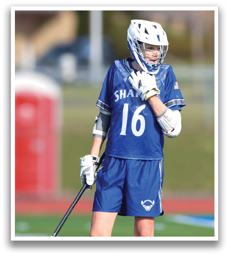 A woman wearing a blue and white uniform stands on a field holding a stick. AI generated content