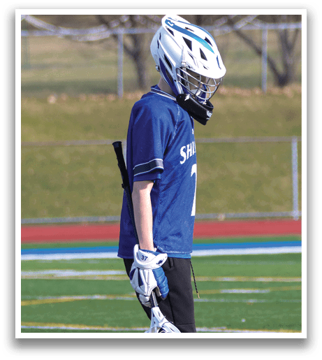 A boy wearing a blue and white jersey walks on a field while holding a baseball glove. AI generated content