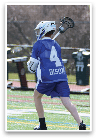 A young man wearing a blue and white jersey is holding a lacrosse stick and preparing to play. AI generated content