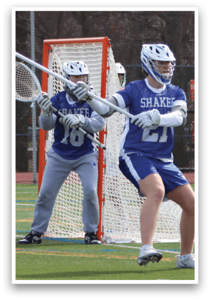 Two lacrosse players are on a field, one holding a stick and the other wearing a helmet. AI generated content