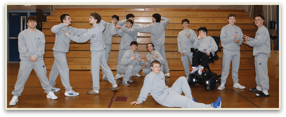 A group of young men in grey sweatshirts pose for a picture in a gym. AI generated content