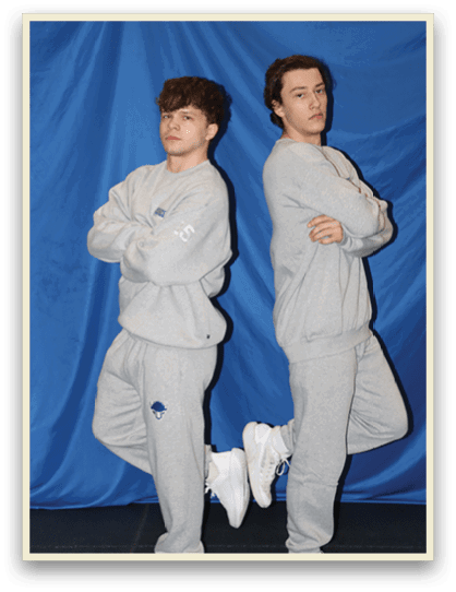 Two young men wearing gray sweatsuits pose for a picture. AI generated content