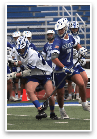 Two men playing lacrosse on a field. One man is wearing a blue and white uniform and is holding a stick. The other man is wearing a white uniform and is attempting to block the first man's shot. AI generated content