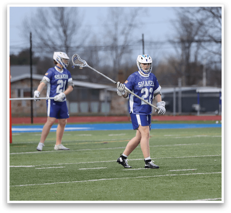 A group of lacrosse players on a field, one holding a stick. AI generated content