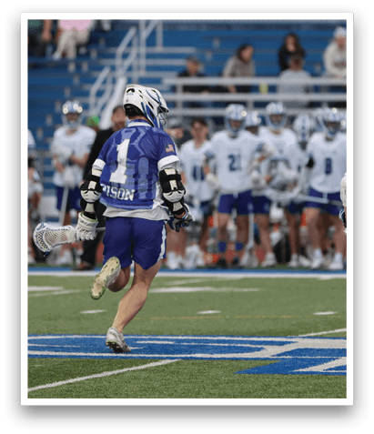 Two lacrosse players running on a field with a crowd of people watching. AI generated content