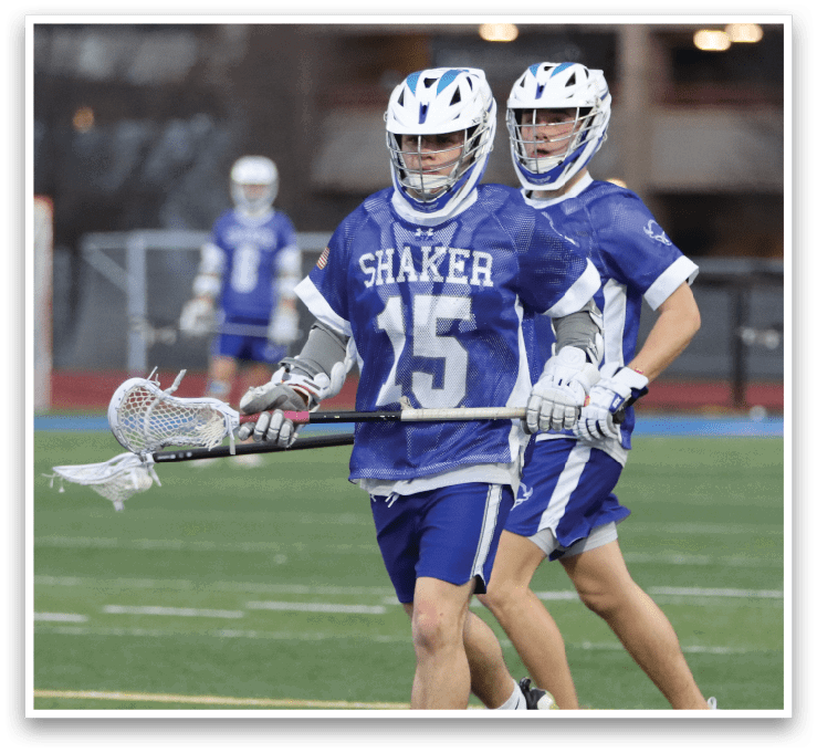 Two lacrosse players in blue uniforms running on a field. AI generated content