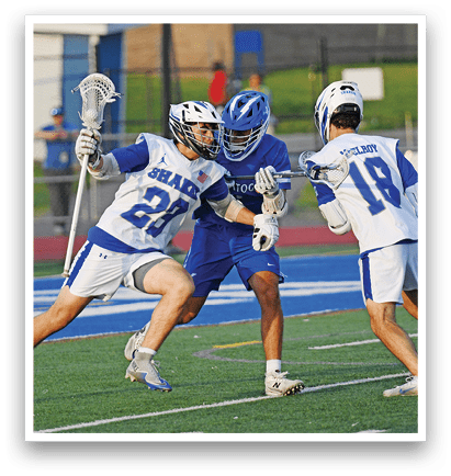 Three men playing lacrosse on a field. Description generated by AI