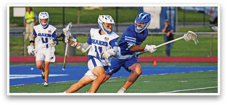 A man in a blue and white uniform is running with a lacrosse stick. Description generated by AI