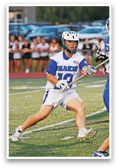 A man in a blue and white uniform is holding a stick. Description generated by AI
