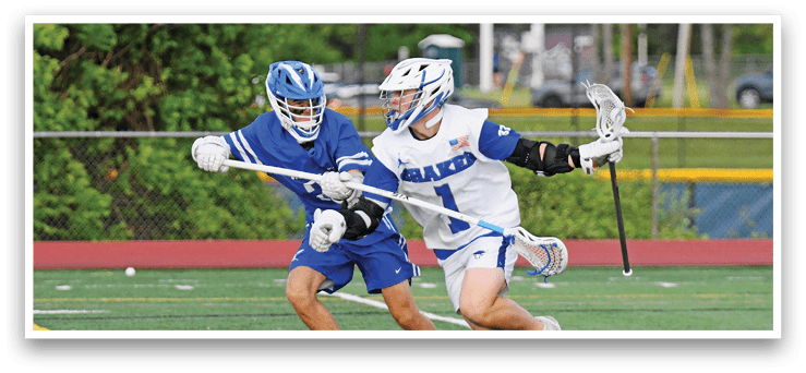 Two men playing lacrosse on a field. Description generated by AI