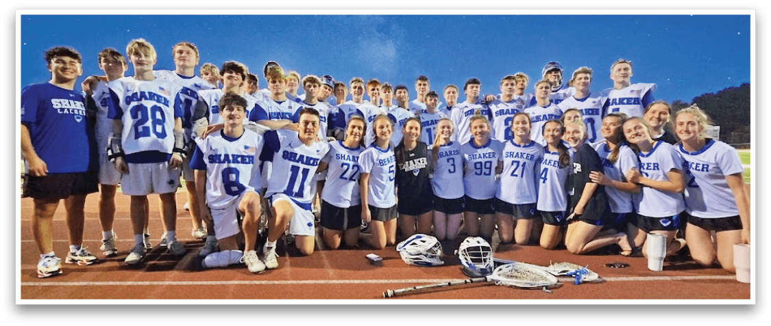 A group of people posing for a picture on a field. Description generated by AI