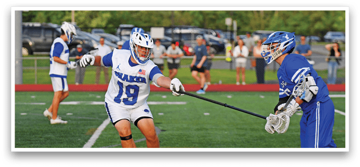 A man in a white and blue uniform is holding a stick. Description generated by AI