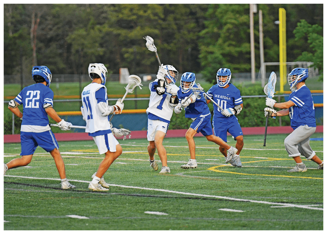 A group of men playing lacrosse on a field. Description generated by AI