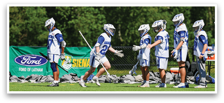 A group of people wearing blue and white uniforms are standing on a field. Description generated by AI