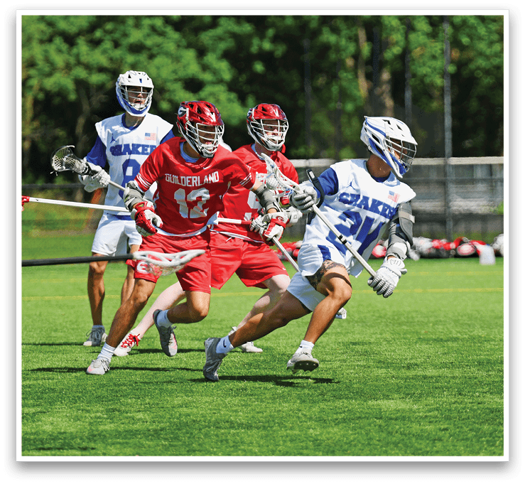 A group of men playing lacrosse on a field. Description generated by AI