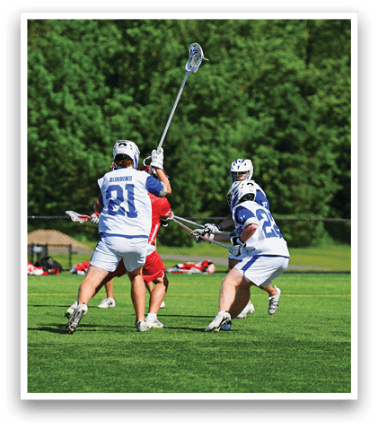 A group of men playing lacrosse on a field. Description generated by AI