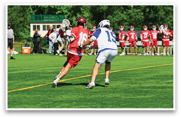 A man in a red jersey is trying to get past a man in a white jersey. Description generated by AI