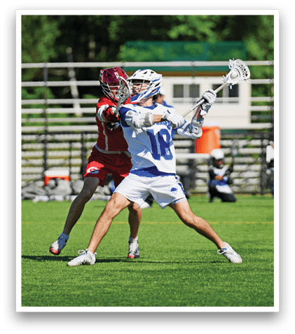 A man wearing a red shirt and white shorts is playing lacrosse. Description generated by AI