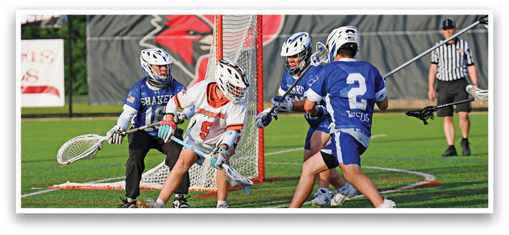 Two men playing lacrosse on a field. Description generated by AI