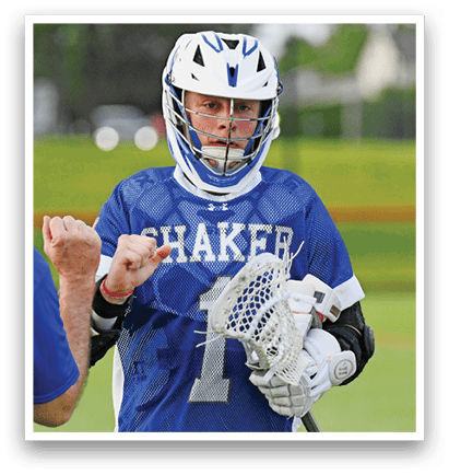 Three men playing lacrosse on a field. Description generated by AI