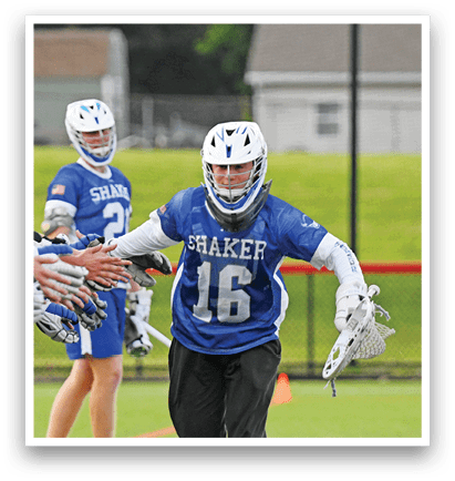 Three men playing lacrosse on a field. Description generated by AI
