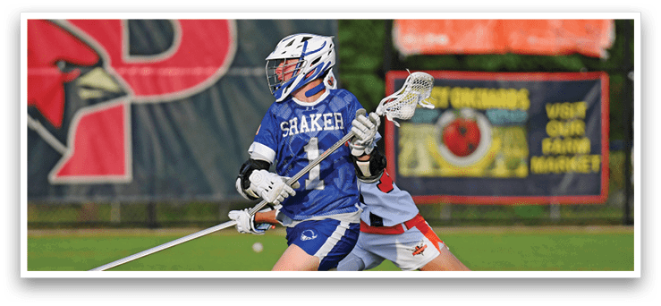 A man in a blue and white uniform is running with a lacrosse stick. Description generated by AI