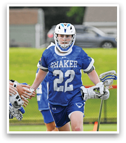 A man in a white and blue uniform is playing lacrosse. Description generated by AI