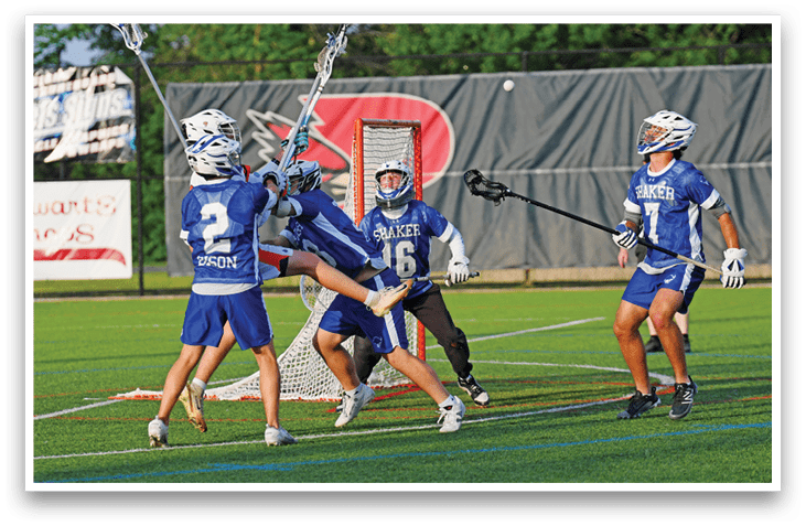 Two men playing lacrosse on a field. Description generated by AI