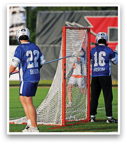 A man in a white and blue uniform is playing lacrosse. Description generated by AI