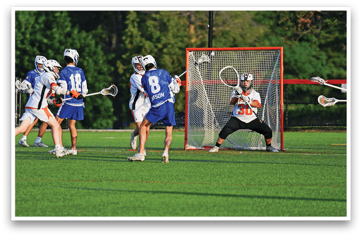 Two men playing lacrosse on a field. Description generated by AI