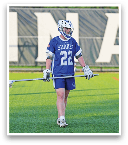 A man in a white and blue uniform is playing lacrosse. Description generated by AI