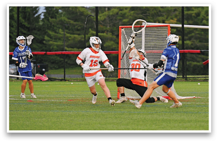 Two men playing lacrosse on a field. Description generated by AI