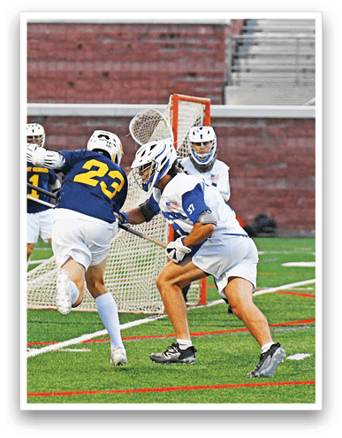 Two people in sports uniforms and helmets are playing lacrosse near a goal on a field with artificial turf. Description generated by AI