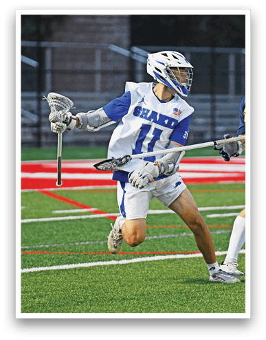 A person wearing a white and blue sports uniform and helmet is running on a field while holding a lacrosse stick. Description generated by AI