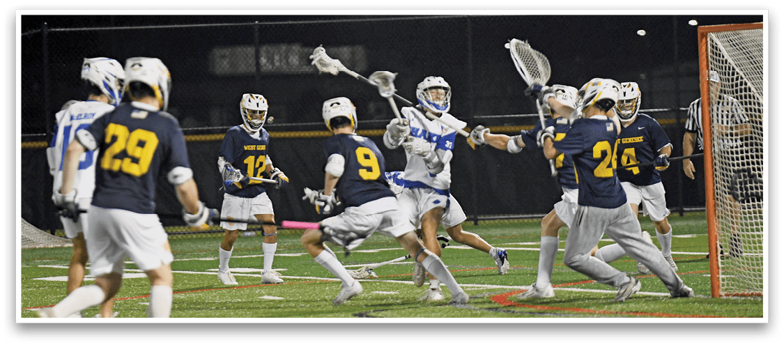 People wearing helmets and sports uniforms are actively playing lacrosse on a field near a goal at night. Description generated by AI