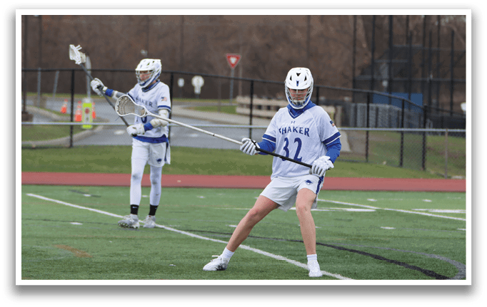 Two men playing lacrosse on a field. One player is holding a stick and preparing to shoot the ball. AI generated content