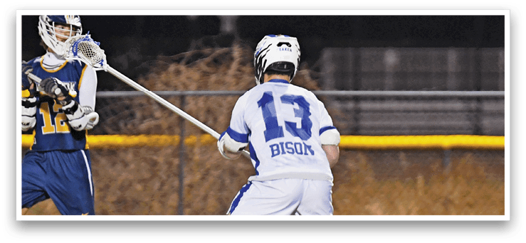 Two men are playing a game of lacrosse on a field. One man is holding a lacrosse stick and the other is running towards him. AI generated content