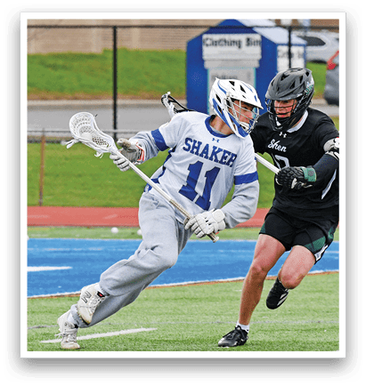 Two men playing lacrosse on a field. One man is running with a stick, while the other is trying to block him. AI generated content