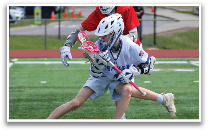 Two girls are playing a game of lacrosse on a field. One girl is trying to get past the other girl who is trying to block her. AI generated content