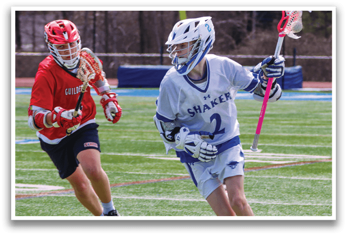 A man in a white and blue jersey is running on a field while holding a lacrosse stick. AI generated content