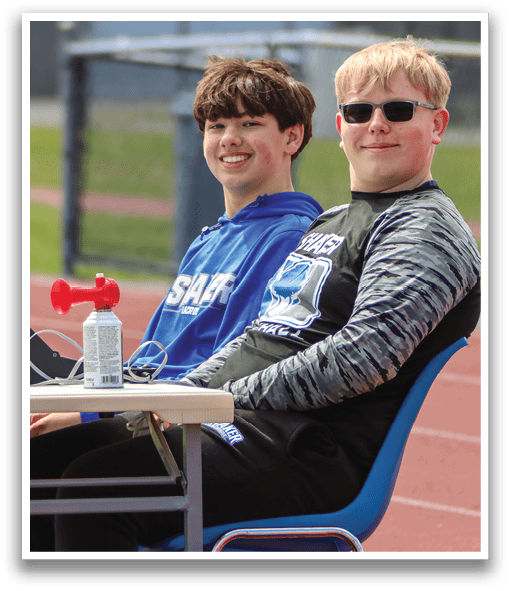 Two boys sitting at a table with a t-shirt on it. AI generated content