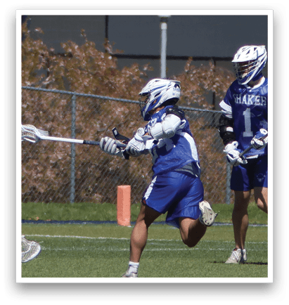 A group of men playing lacrosse on a field. One player is holding a stick and trying to get past the goalie. AI generated content