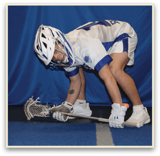 A man wearing a helmet and kneeling down with a lacrosse stick. AI generated content