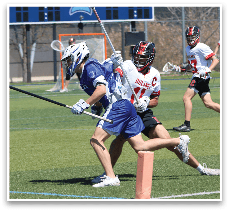 A lacrosse game is in progress with players running across the field. One player is holding a lacrosse stick and appears to be running towards the goal. Another player is running with a lacrosse stick in hand. The players are wearing blue and white uniforms. AI generated content