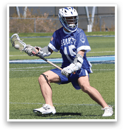 A man wearing a blue and white shirt and white pants is holding a lacrosse stick. AI generated content